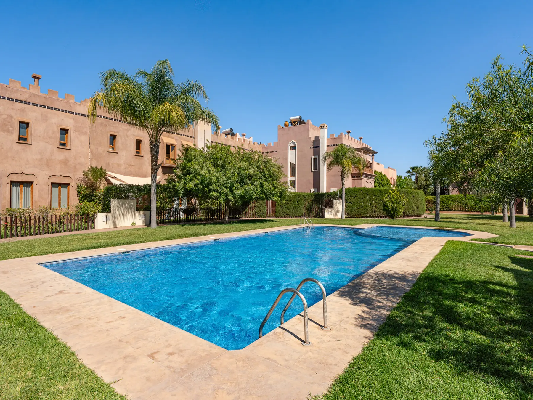 Grande piscine paysagée de la résidence accessible aux voyageurs de Villa Assi Prestige