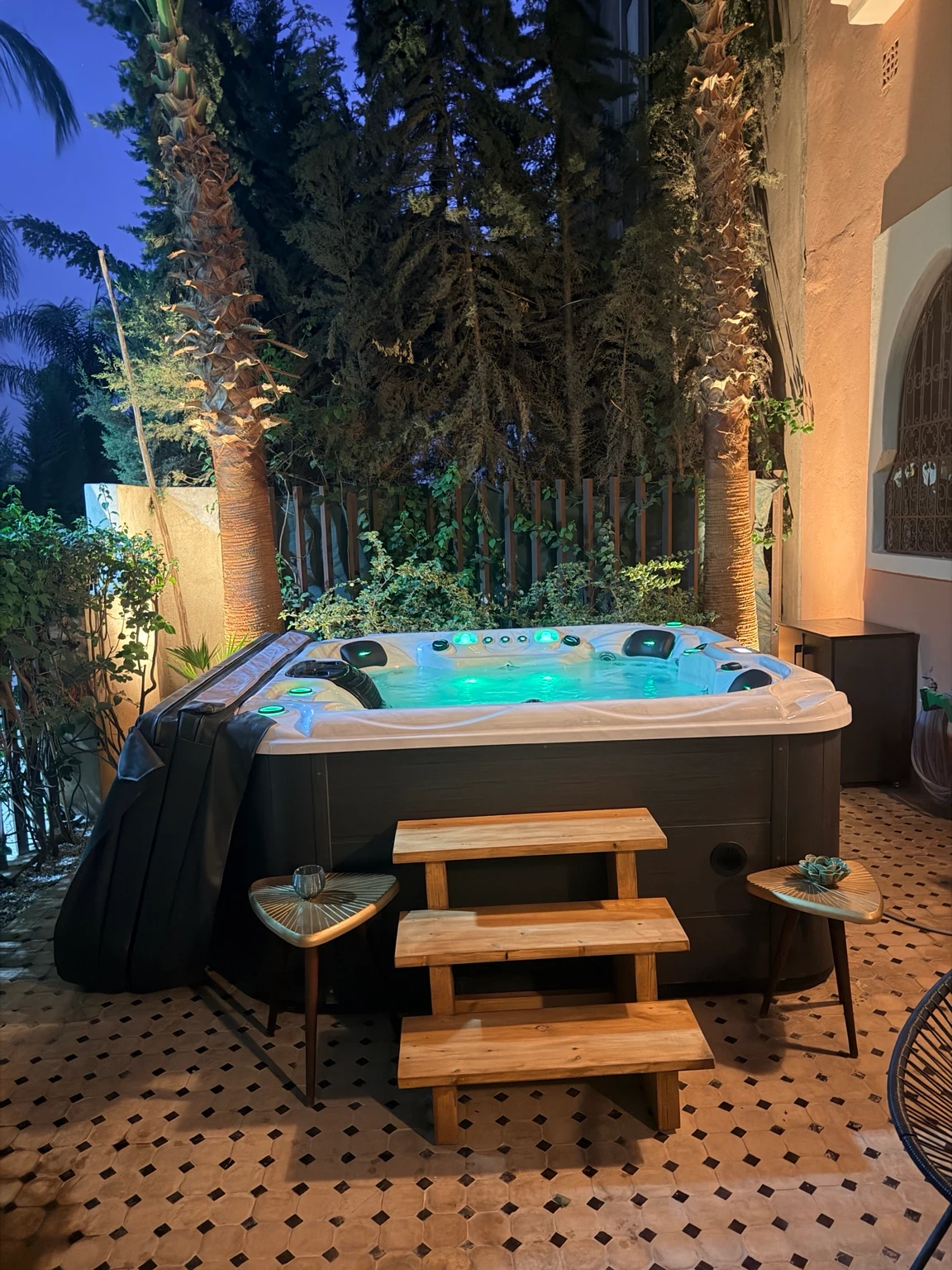Spa Lea : jacuzzi ouvert, marches en bois et palmiers au crépuscule